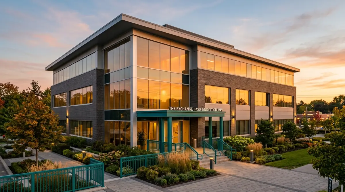 Modern commercial office building exterior at golden hour with glass facades reflecting warm light